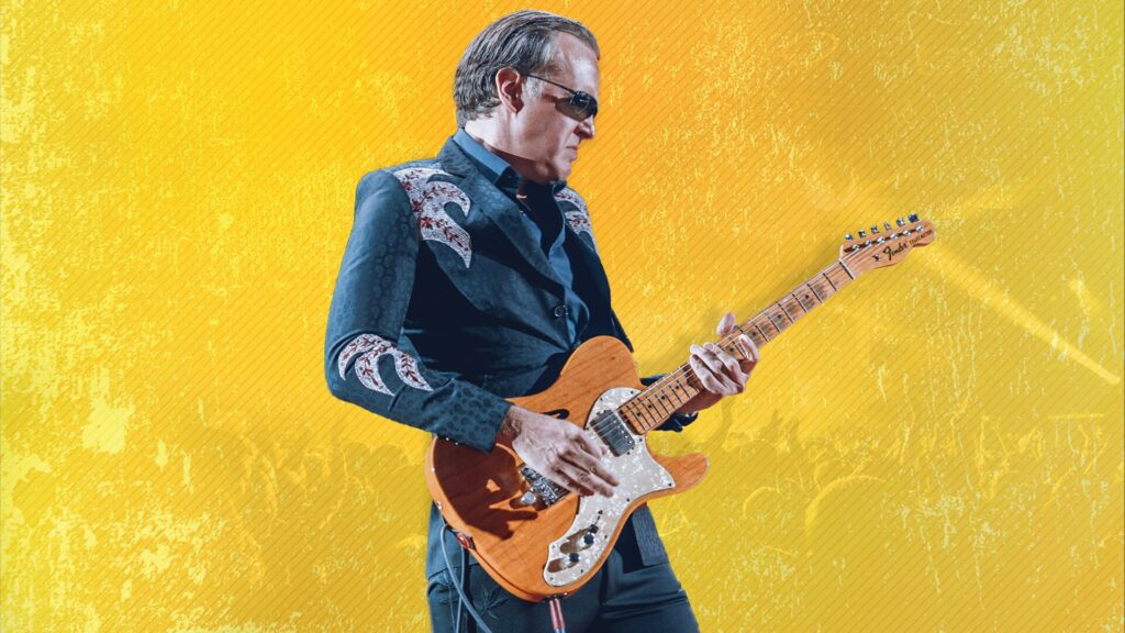 Joe Bonamassa with guitar on yellow background